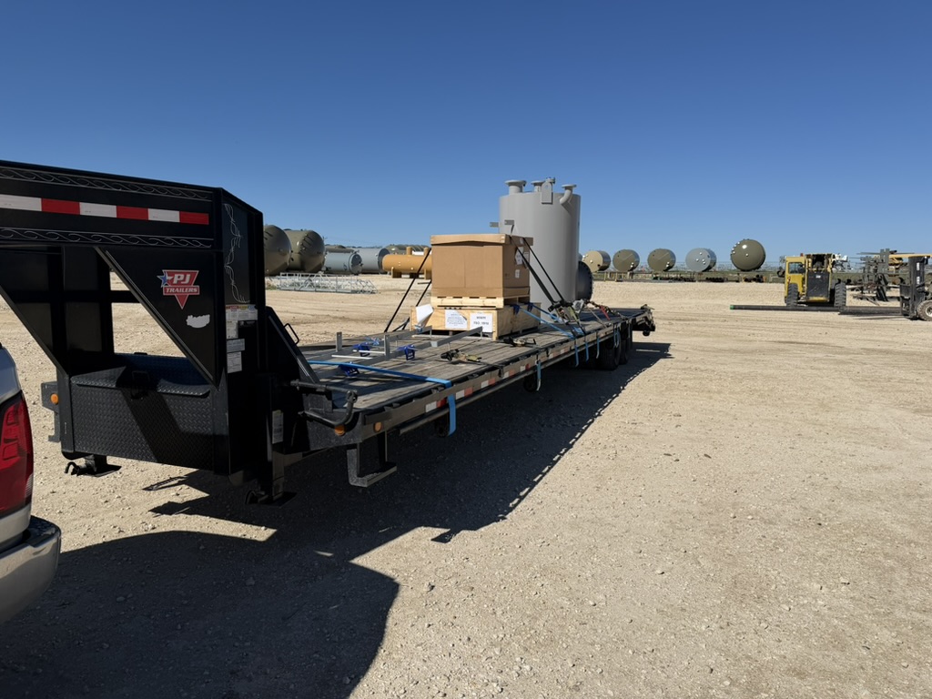 Gooseneck flatbed rig staged for freight loading
